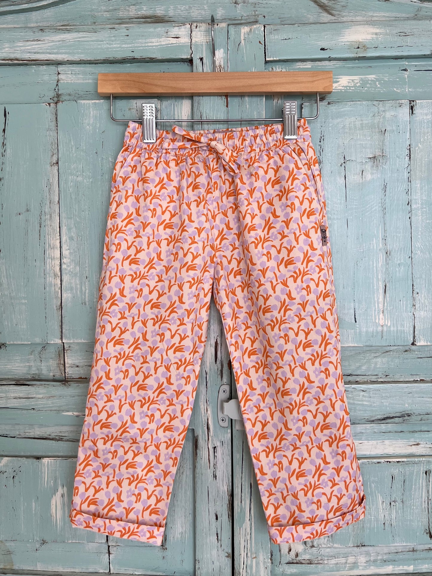 Organic cotton long pants, adjustable in length, with a pink and orange botanical print, tulip flowers, relaxed fit, pajama pants style, elastic waistband and adjustable drawstring.Age 2 to 8 years old
