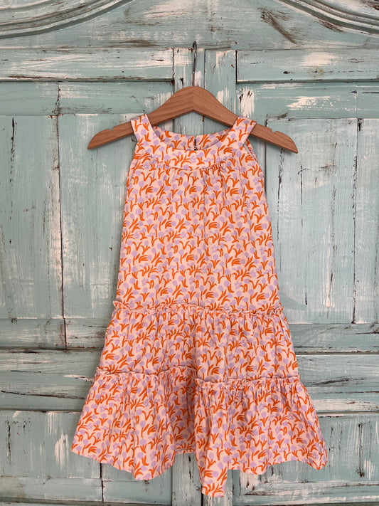 Sleeveless organic cotton dress for girls age 2 to 7, with a soft antique pink background and a vibrant  orange and violet tulips print.
Features high neckline and tiered ruffle skirt for a playful flow look.Fabric button on the back neck line for easy fit
