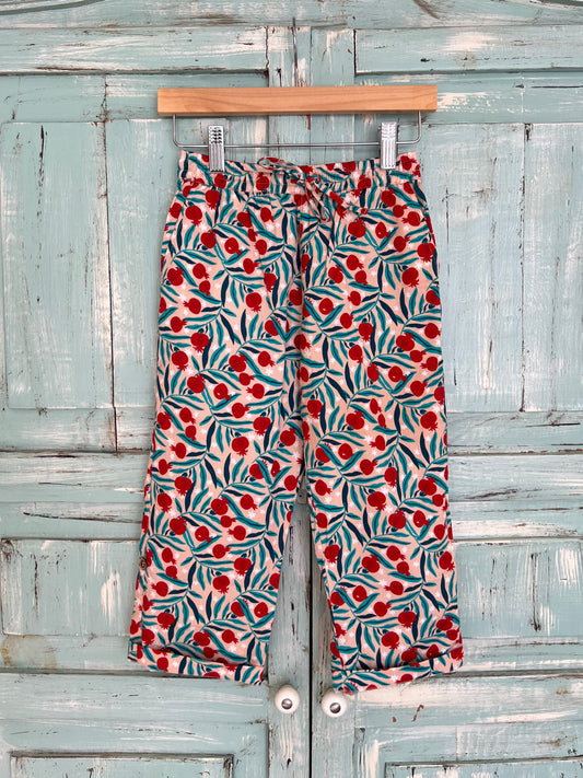 Organic cotton long pants, adjustable in length, with a pink base and green and red botanical print, pomegranate, relaxed fit, pajama pants style, elastic waistband and adjustable drawstring.Age 2 to 9 years old