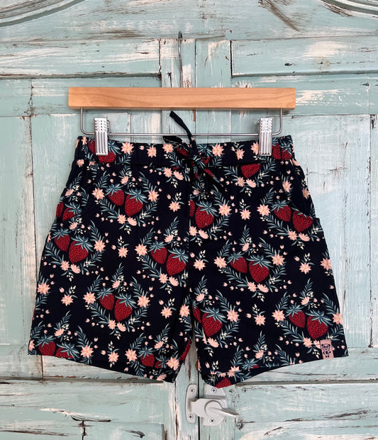 organic cotton shorts for kids age 2 to 9 years old, soft black  base with strawberry and leaf print, relaxed fit, elastic waistband, and an adjustable drawstring.