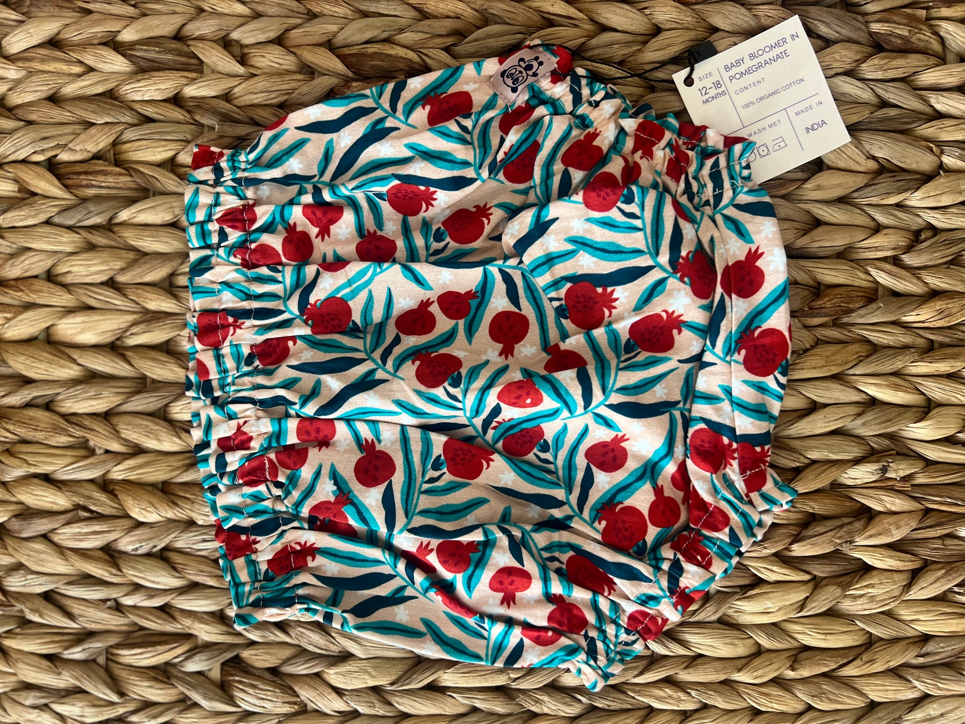organic cotton baby bloomers with pomegranate print. designed for 9 to 12 and 12 to 18 months old babies. soft, breathable, and eco-friendly with a playful fruit-theme pattern