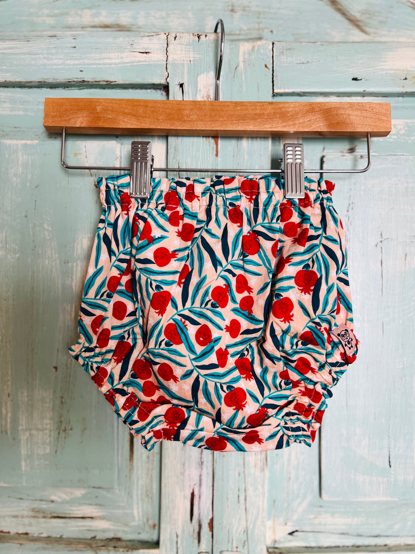 organic cotton baby bloomers with pomegranate print. designed for 9 to 12 and 12 to 18 months old babies. soft, breathable, and eco-friendly with a playful fruit-theme pattern